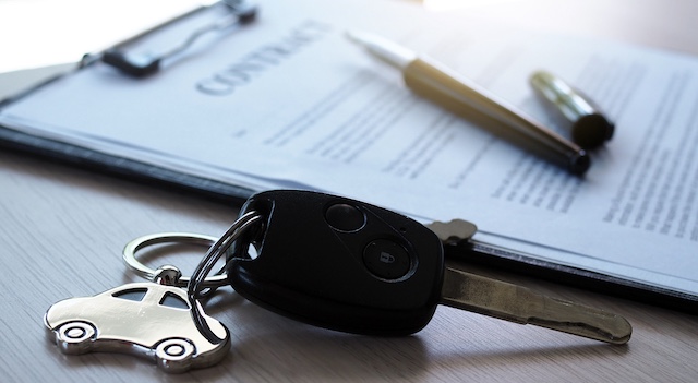 Car keys placed on contract documents about car loans.